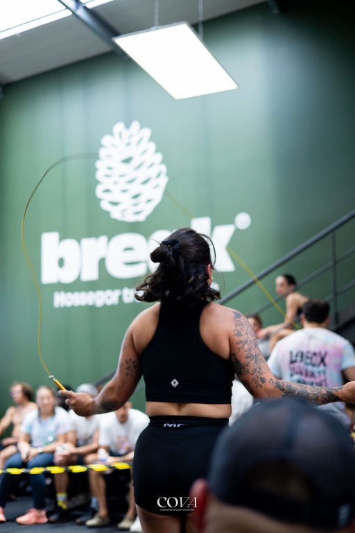 Une adhérente enchaîne les sauts à la corde devant le mur au logo Break.